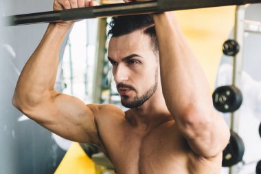 Spor salonunda çıplak poz veren yakışıklı sporcu erkek vücut geliştirici.