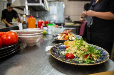 Oteldeki mutfak restoranında yemek pişiren profesyonel bir aşçı. Yemek hazırlıyor. Yemek servisi.