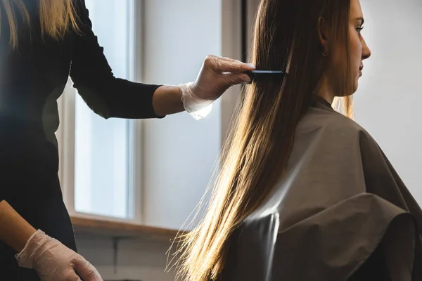 Cabeleireiro mestre penteia o cabelo das meninas após a lavagem e antes de styling em um salão de beleza. — Fotografia de Stock
