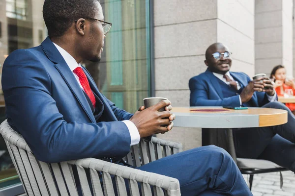Encuentro de dos viejos amigos del hombre de negocios afroamericano negro en trajes al aire libre en un café de verano de la ciudad —  Fotos de Stock