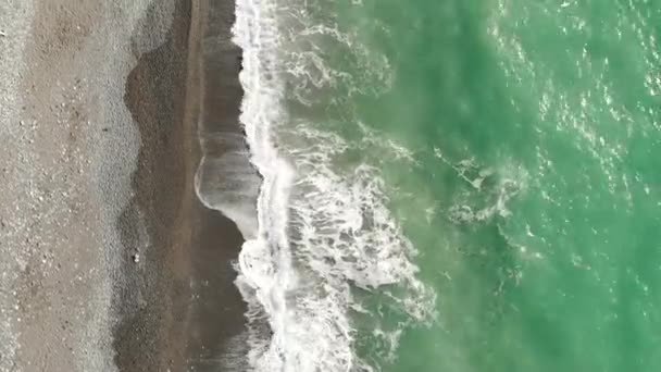 Légi felvétel egy drónról. A part mentén repül. Unalmas árapály. Hullámok borítják a partot közelről fentről és hab. — Stock videók