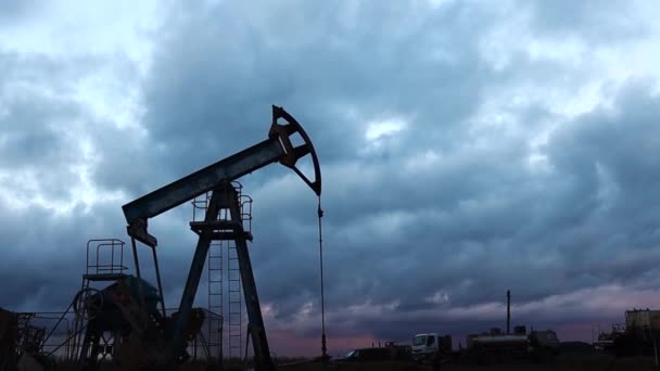 Trabajo de la bomba de barra de succión de silueta y aceite de la bomba contra el fondo del cielo de la noche — Vídeo de stock