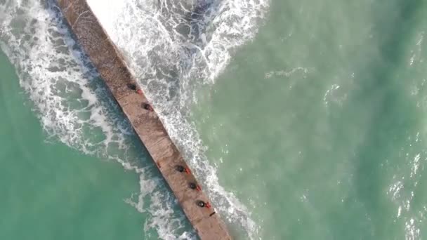 Aerial photography from a drone. Flying along the coast. Tidal bore. Waves roll over the shore close-up from above and foam. — Stock Video