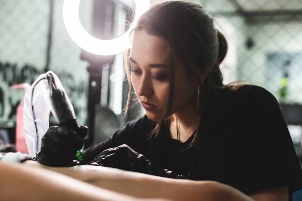 Bacağa yakın plan dövme çizimi. Kadın dövme sanatçısı bir sanat stüdyosunda özel bir makineyle çizim yapıyor. — Stok fotoğraf