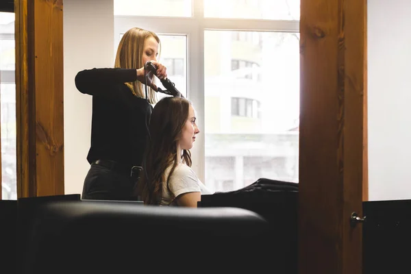 Mistryně žena kadeřnice jemně kudrlinky vlasy curling dívka v salonu krásy. Styling vlasů — Stock fotografie