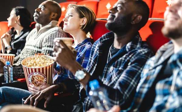 Amigos viendo una película en el cine con palomitas de maíz. La gente se sienta en los sillones del cine y mira la pantalla — Foto de Stock