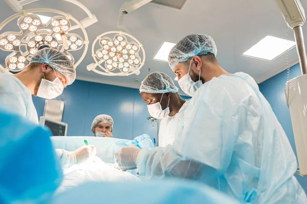 Le chirurgien principal dans la salle d'opération, où le patient l'attend, et il commence l'opération. — Photo