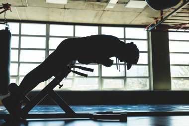 Genç bir adam özel bir simülatör üzerinde basın çalışması yapıyor. Siluet atışı