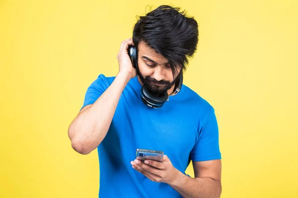 Retrato emocional de un hombre hindú con una camiseta azul sobre un fondo amarillo — Foto de Stock