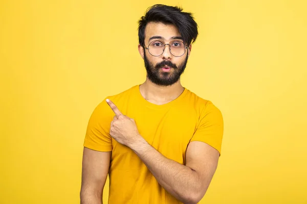 Ritratto emotivo di un uomo indù in una t-shirt gialla su uno sfondo arancione brillante. — Foto Stock