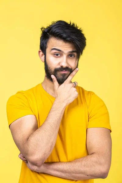 Retrato emocional de un hombre hindú con una camiseta amarilla sobre un fondo naranja brillante —  Fotos de Stock