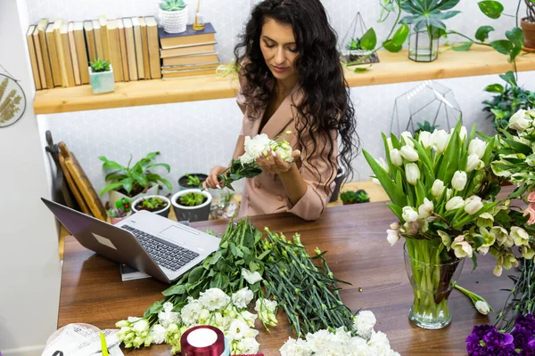 Приваблива молода жінка-флорист працює в квітковому магазині . — стокове фото