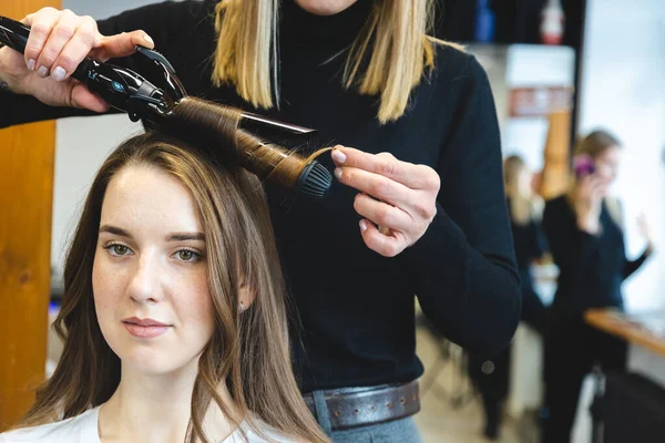 Master γυναίκα κομμώτρια απαλά μπούκλες μαλλιά κορίτσι μπούκλες σε ένα σαλόνι ομορφιάς. Κομμωτήριο — Φωτογραφία Αρχείου