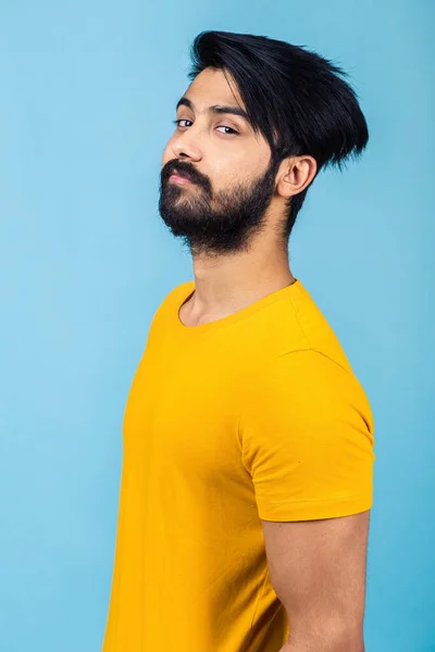 Ritratto emotivo di un uomo indù in t-shirt gialla su sfondo blu brillante — Foto Stock