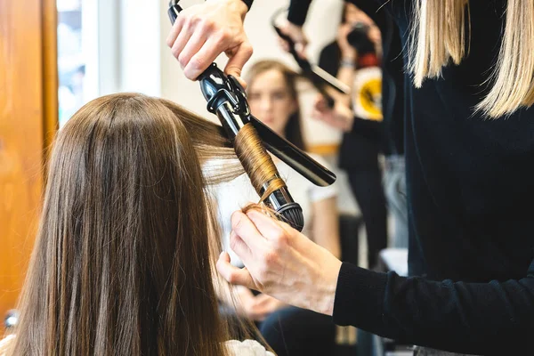 Mester nő fodrász finoman fürtöl haj curling lány egy szépségszalonban. Hajformázás — Stock Fotó