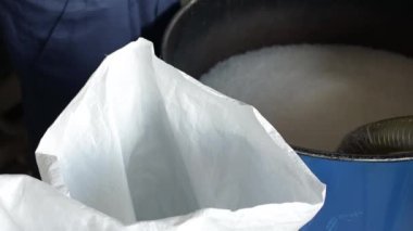 Erkek el ele tutuşur ve PP Pet Chips Semi Dull, PET Cipsleri, PET Polyester Cipsleri karıştırır.