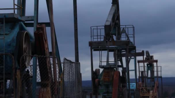 Las bombas de vástago están trabajando y bombeando aceite contra el telón de fondo del cielo nocturno. Servicio de pozo de petróleo — Vídeo de stock