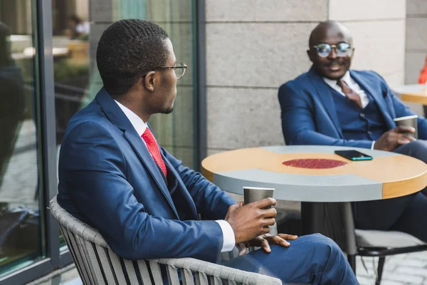 Rencontre de deux amis de longue date d'un homme d'affaires noir afro-américain en costume à l'extérieur dans un café de la ville d'été — Photo