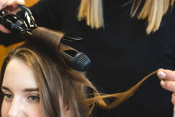 Friseurmeisterin lockert in einem Schönheitssalon sanft das Haar. Haarstyling — Stockfoto
