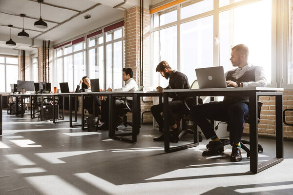 Group of young business people in smart casual wear working together in office. Team at work.