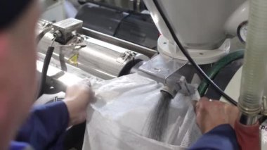 Fabrika işçisi bir çantayı polipropilen granüllerle dolduruyor. Fıçı PP Pet Chips Semi Dull, PET Cipsleri geri dönüşüm, PET Polyester Cipsler