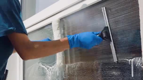 Um trabalhador profissional de uma empresa de limpeza lava as janelas da empresa com produtos químicos especiais — Vídeo de Stock