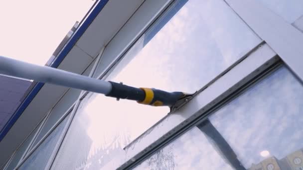 Detailní video specialisty na úklidové služby umývá a čistí okna a fasádu budovy — Stock video
