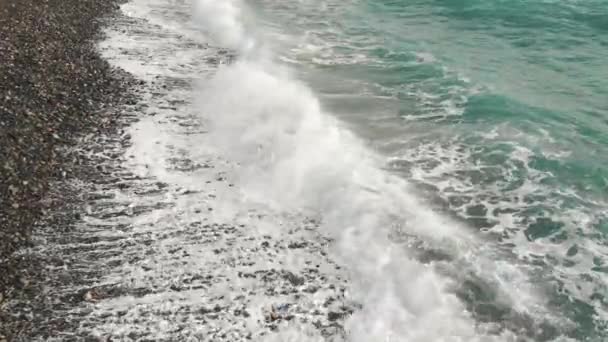Çakıl taşlı bir sahilde deniz sörfüne yakın çekim — Stok video