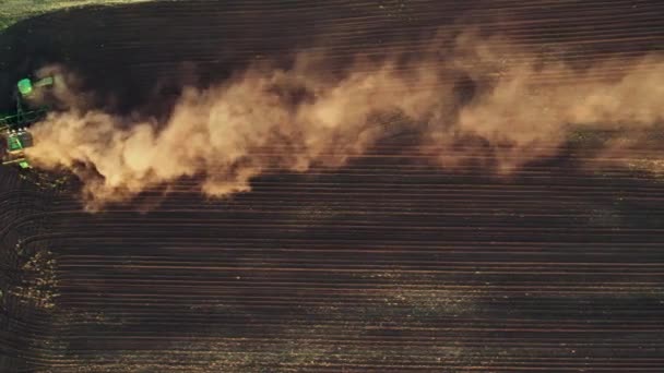 Letecký záznam z 4K traktoru, který orá pole a vítr zvedá prach. Příprava půdy na další sklizňovou sezónu — Stock video
