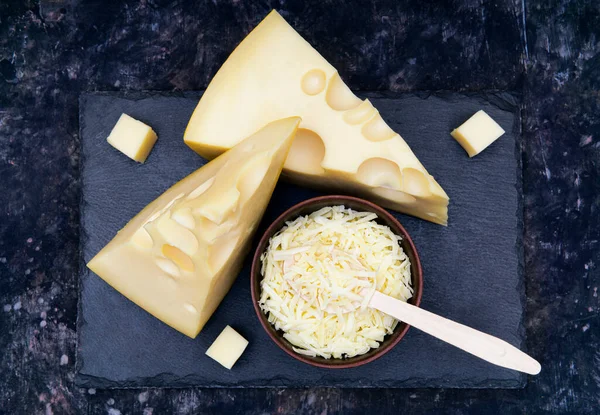 Twee Kaas Wiggen Een Kom Geraspte Kaas Een Zwarte Stenen — Stockfoto