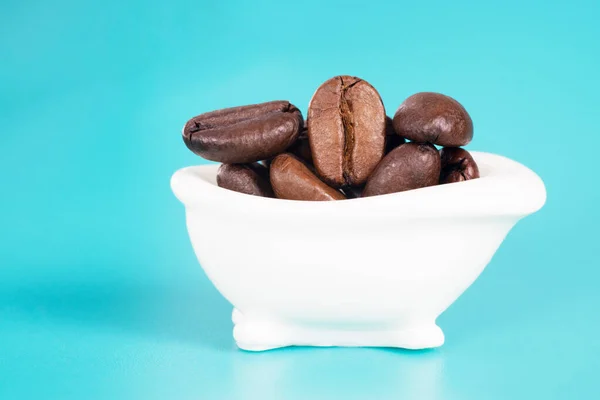 Närbild Liten Vit Badkar Full Rostade Kaffebönor Ljusblå Bakgrund Morgonrutin — Stockfoto