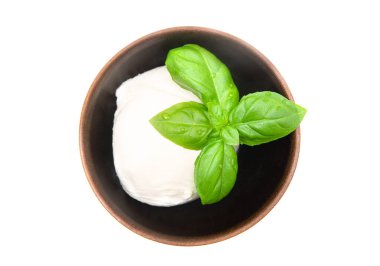 Üzerinde taze fesleğen yaprakları olan Mozzarella topu beyaz üzerine izole edilmiş küçük bir ahşap kase içinde. Üst-görüntü, yakın-plan.