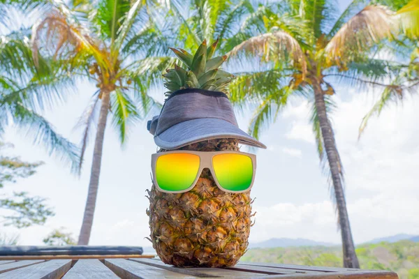 有趣的菠萝角色 戴着渐变太阳镜 头戴太阳帽 躺在棕榈树下晒太阳 热带假期的概念 — 图库照片