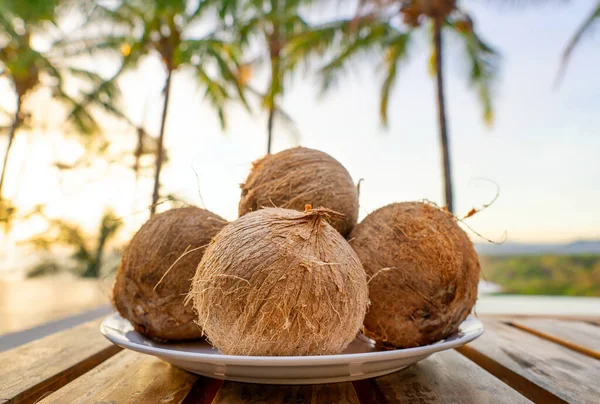 热带背景下木制桌子上有四个椰子的白板的特写 — 图库照片