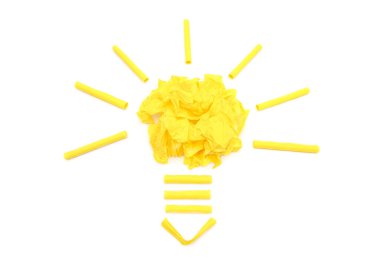 Light bulb symbol made from a large pile of crumpled paper balls and waste office papers isolated on white background. Creative idea development concept.