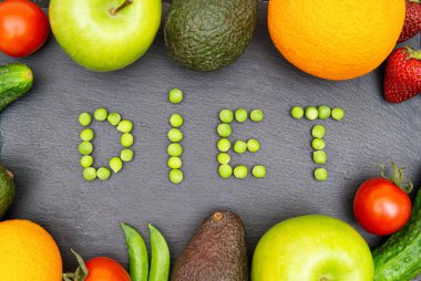 Siyah desenli arka planda çeşitli meyve ve sebzelerle çerçevelenmiş yeşil bezelyelerden oluşan bir diyet. Dengeli organik diyet kavramı.