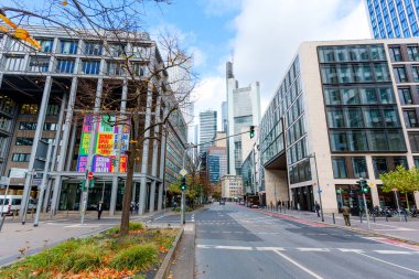 Frankfurt, Germany - October 21, 2025: Serene view of a tree-lined street in Frankfurt showcasing modern architecture and autumn colors.