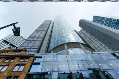 Frankfurt, Germany - October 21, 2025: Frankfurt's financial district showcases the iconic Main Tower, a towering glass skyscraper, amidst modern buildings and an older stone facade.