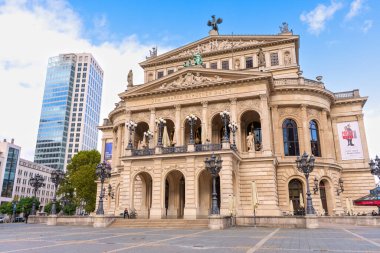 Frankfurt, Germany - October 21, 2025: Frankfurt's iconic Alte Oper and a sleek modern skyscraper stand proudly on a sunny day. A striking architectural contrast in Germany's financial hub.