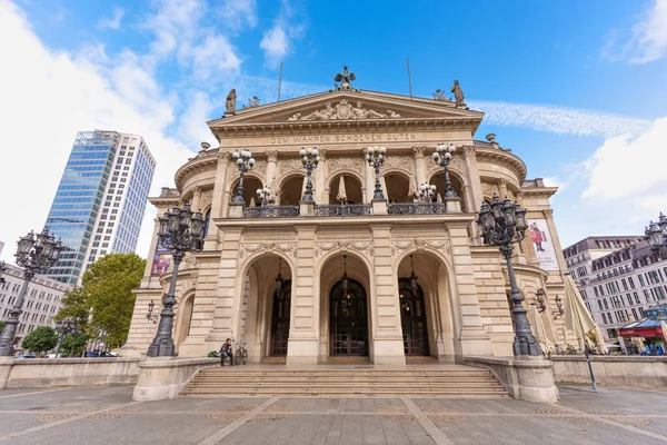 Frankfurt, Germany - October 21, 2025: Frankfurt's neoclassical Alte Oper building stands against a modern skyscraper under a blue sky, wide angle shot.