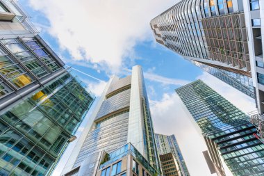 Frankfurt, Almanya - 21 Ekim 2025: Frankfurt 'un etkileyici gökdelenleri parlak, bulutlu mavi gökyüzü altında geniş açılı geniş perspektifli cam ve çelik gökdelenler sergiliyor.