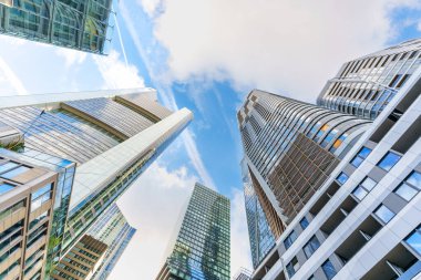 Frankfurt, Almanya - 21 Ekim 2025: Modern cam gökdelenler Frankfurt 'un finans bölgesindeki parlak mavi gökyüzüne doğru süzülüyor, alçak bir açıdan geniş açı ile çekiliyor