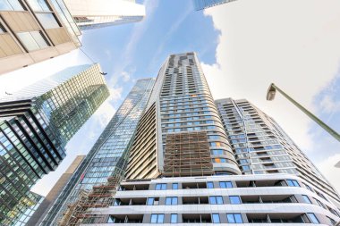 Frankfurt, Almanya - 21 Ekim 2025: Parlayan cam ve çelik gökdelenler Frankfurt, Almanya 'da çağdaş kentsel gelişimi gösteren açık bir gökyüzüne yükseldi.