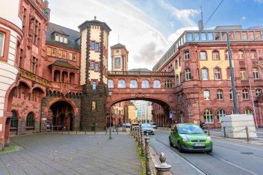 Frankfurt, Almanya - 21 Ekim 2025: Tarihi kırmızı kumtaşı Alte Brcke, berrak mavi gökyüzüne karşı güzelliği yansıtan sakin ana nehrin üzerinde görkemli bir şekilde kemer sallıyor