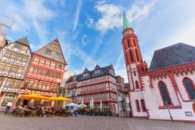 Frankfurt, Almanya - 21 Ekim 2025: Frankfurt 'un tarihi Roemerberg meydanında St. Bartholomew Katedrali, geleneksel yarı keresteli evler ve hareketli açık hava kafeler yer almaktadır.