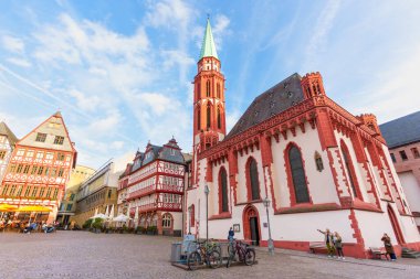 Frankfurt, Almanya - 21 Ekim 2025: Frankfurt 'un tarihi Roemerberg meydanında St. Bartholomew Katedrali, geleneksel yarı keresteli evler ve hareketli açık hava kafeler yer almaktadır.
