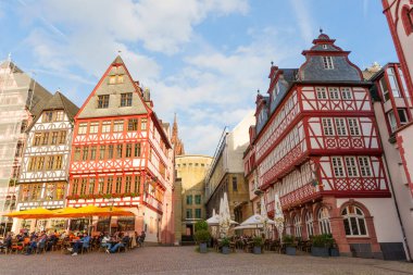 Frankfurt, Almanya - 21 Ekim 2025: Canlı sokak sahneleri Frankfurt 'un titizlikle restore edilmiş yarım keresteli binalarını ve açık hava kafelerinin keyfini çıkaran insanları gözler önüne seriyor.