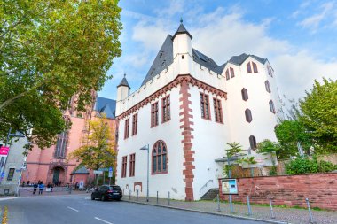 Frankfurt, Almanya - 21 Ekim 2025: Beyaz duvarları ve kırmızı kumtaşı süslemeleri ile tarihi Saalhof binası Frankfurt 'un Eski Aziz Nicholas Kilisesi yakınlarında açık mavi bir gökyüzünün altında duruyor..