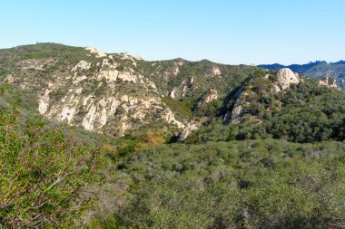 Geniş arazide engebeli, şapel kaplı yamaçlar ve Kızıl Kaya Kanyon Parkı 'ndaki parlak gökyüzü altında kendine özgü kumtaşı kaya oluşumları bulunur..
