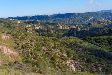 Uçsuz bucaksız manzara, Kızıl Kaya Kanyon Parkı 'nın engebeli, fırça kaplı arazisini, belirgin kaya çıkıntılarını, yeşil yamaçları ve açık bir gökyüzünün altındaki uzak tepeleri gözler önüne serer..